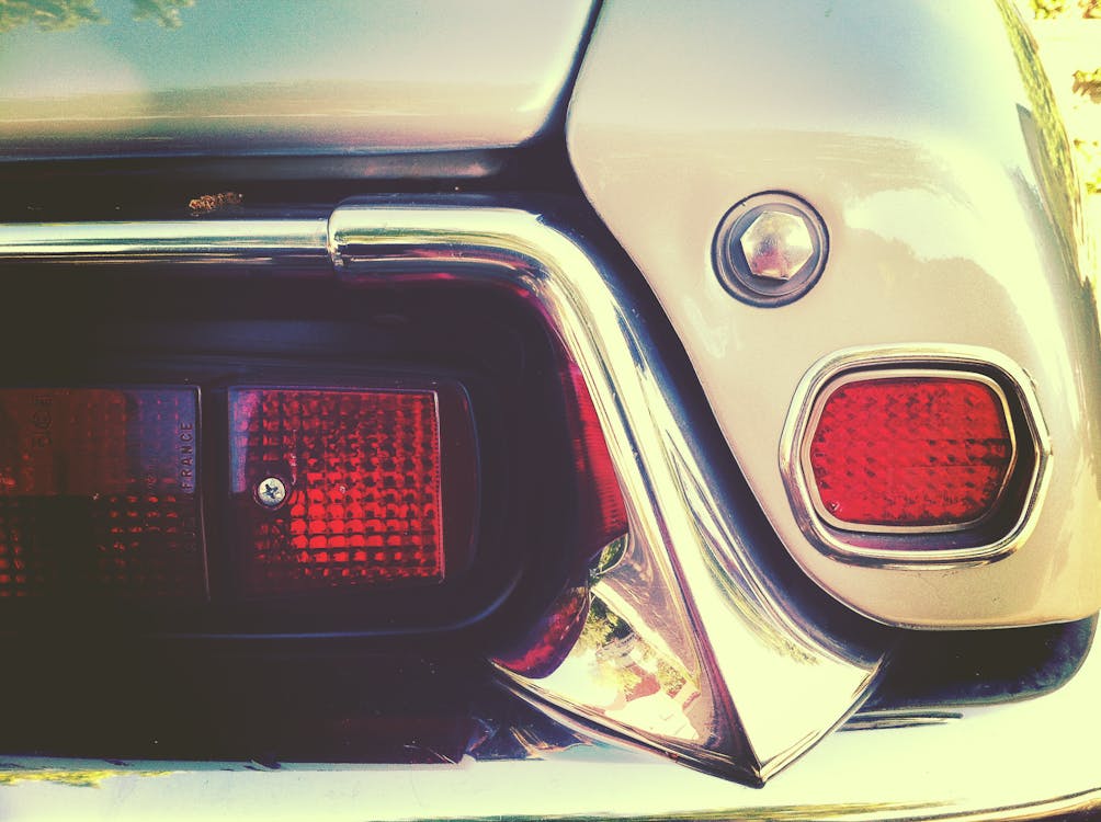 Detailed close-up of a car showcasing a striking red light emphasizing the vehicle's modern features perfect for those looking to restore chrome bumper