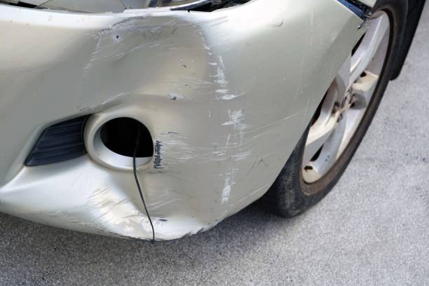 A front view of a damaged car prominently displaying a dent on the bumper suggesting prior impact—covered by Chrome Bumper Repair Insurance Coverage