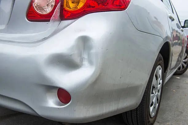 A car with a visibly damaged bumper is parked highlighting the extent of the damage on the vehicle's front end and in need of a quick fix for bumper falling off