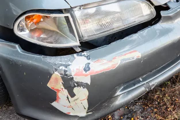  A car with visible damage prominently displaying a sticker on the front indicating its current state and character highlighting the need to repair cracked bumper cover