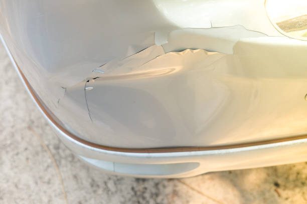 Close-up image of a car's front featuring how to put a bumper on a car to fix a distinct dent that affects its appearance